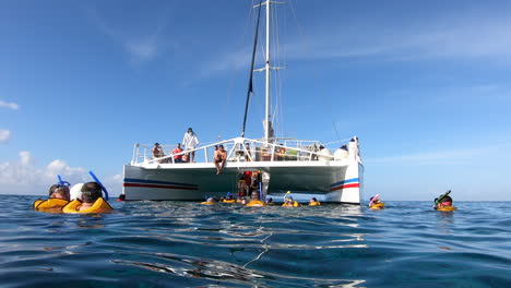 Turista-Con-Chalecos-Salvavidas-Y-Máscaras-De-Snorkel-Moviéndose-Dentro-Del-Velero-Catamarán-En-Medio-Del-Mar-|-Experiencia-De-Tour-De-Natación-Y-Esnórquel-En-El-Océano-|-Catamarán,-Turismo,-Snorkel,-Aventura