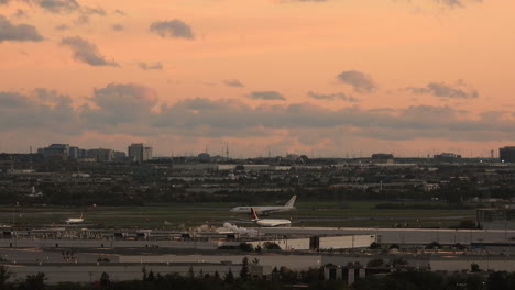 Ajetreado-Aeropuerto-De-Toronto-Con-Cielo-Naranja-Al-Atardecer,-Vista-De-Lapso-De-Tiempo-Estático