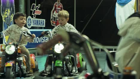 Niños-Pequeños-Divirtiéndose-Montando-Autos-Chocadores-En-El-Carnaval-De-San-Froilan-Lugo,-De-Noche