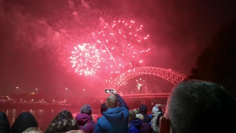 La-Gente-Ve-Coloridos-Fuegos-Artificiales-Explotando-En-El-Puente-Del-Jubileo-De-Plata,-Ancho