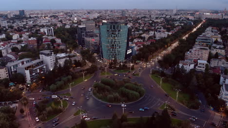 Plaza-Charles-De-Gaulle-Al-Atardecer-Con-Tráfico-Y-Vista-Aérea-Del-Edificio-De-Oficinas,-Bucarest,-Rumania