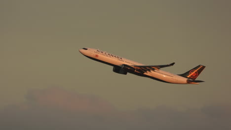 Avión-De-Air-Canada-Escalando-El-Cielo-Nublado-Iluminado-Por-Las-Luces-Del-Atardecer,-Aeropuerto-Internacional-De-Toronto