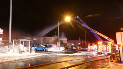 Feuerwehrleute-Löschen-In-Einer-Winternacht-Ein-Brennendes-Haus