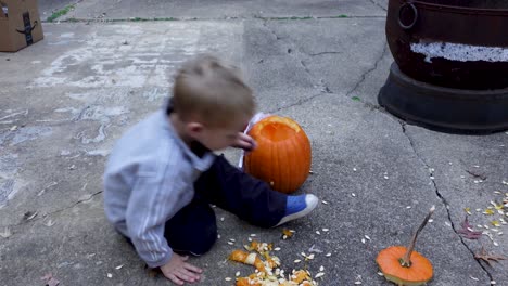 Schöner-Blonder-Junge,-Der-Zur-Halloween-Zeit-Orangefarbenen-Kürbis-Schnitzt-Und-Dekoriert