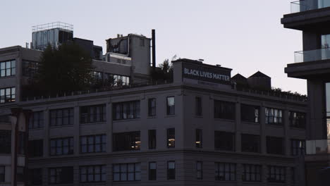 Black-Lives-Matter-sign-board-on-top-of-New-York-building,-handheld-view