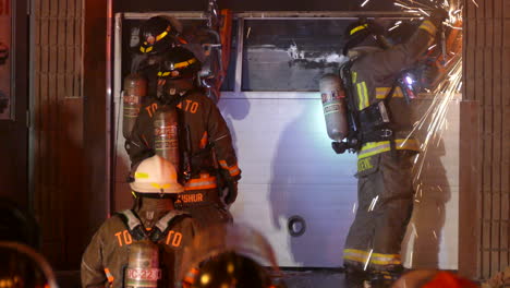 El-Departamento-De-Bomberos-De-Toronto-Usando-Sierras-De-Rescate-Para-Cortar-La-Puerta-Del-Garaje-A-Altas-Horas-De-La-Noche-Con-Chispas-Volando