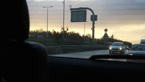 Goldener-Sonnenuntergangshimmel,-Gesehen-Vom-Rückfenster-Des-Autos,-Das-Entlang-Der-Autobahn-In-London-Fährt