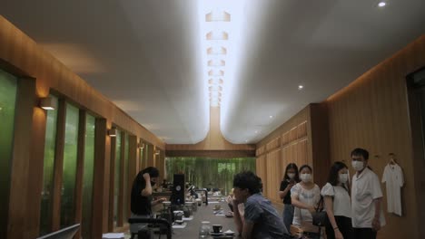 Interior-Con-Vistas-Al-Paisaje-Dentro-De-La-Tienda-De-Café-De-Estilo-Minimalista-Japonés-El-Baristro-Con-Muchos-Clientes-Dentro