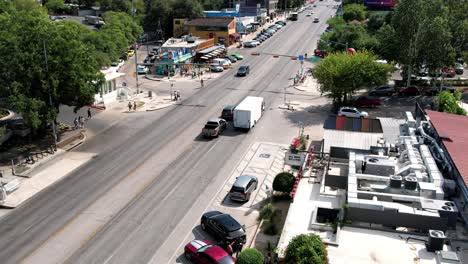 Drone-forward-moving-shot-over-busy-downtown-around-Austin-Motel-in-Texas,-USA-on-a-bright-sunny-day