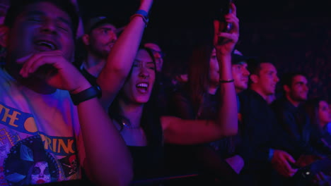 Young-Woman-Lady-Cheering-Singing-and-Dancing-During-Music-Concert-Show-with-CellPhone-in-Hand,-Colorful-Spotlights-and-Spectators-Crowd-Next-to-Her,-Youth-and-Entertainment