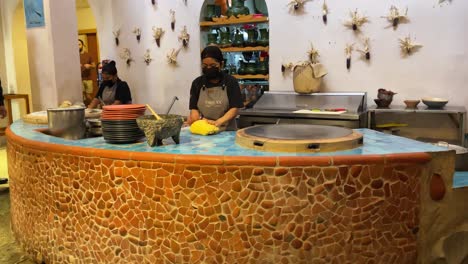 slow-motion-shot-of-a-couple-of-cooks-making-the-dough-for-tortillas-on-a-griddle-in-oaxaca