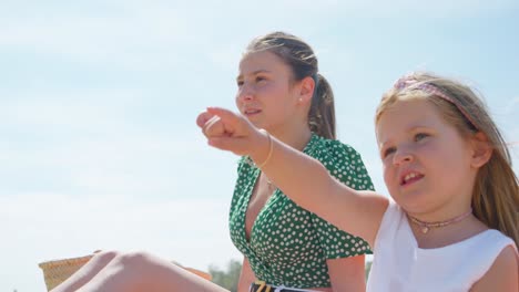 Mutter-Und-Tochter-Sprechen-Miteinander-Und-Das-Mädchen-Zeigt-Etwas-In-Der-Ferne