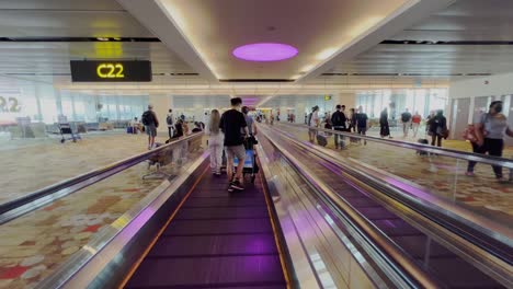 Shot-while-on-horizontal-escalator-device-with-passengers-with-luggage-along-Hydrabad-airport-hall-in-India-at-daytime