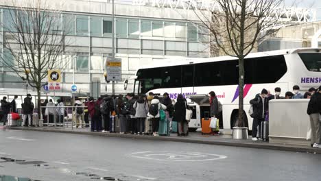 6.-November-2022---Gruppe-Von-Passagieren,-Die-Neben-Dem-Bus-An-Der-Abgabestelle-Am-Heathrow-Terminal-3-Warten