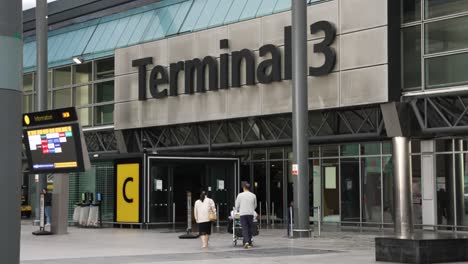 6th-November-2022---Couple-Walking-Towards-Entrance-To-Terminal-3-Departures-At-Heathrow-Airport