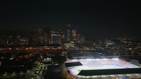 Aerial-view-in-front-of-the-illuminated-PNC-Stadium-with-downtown-Houston-in-the-background