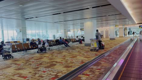 Shot-while-moving-on-horizontal-escalator-device-beside-a-sitting-area-in-hydrabad-airport-hallway-in-India-at-daytime