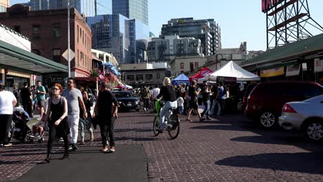 Famoso-Mercado-De-Lucio,-Seattle,-Washington,-Abarrotado-En-Medio-Del-Día,-Conducción-De-Bicicletas-Eléctricas