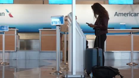 Dame-Am-Flughafen-Interagiert-Mit-Dem-Kiosk-Und-Checkt-Ein-Und-Bereitet-Ihr-Aufgegebenes-Gepäck-Am-Flughafen-Chicago-Der-Amerikanischen-Fluggesellschaft-Ohair-Vor