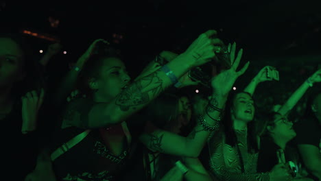 Joven-Mujer-Tatuada-Sosteniendo-Un-Teléfono-Celular-Filmando-Y-Cantando-Durante-Un-Concierto-De-Música,-Audiencia-Multitud-Damas-En-La-Arena-Filmando-Música-En-El-Escenario