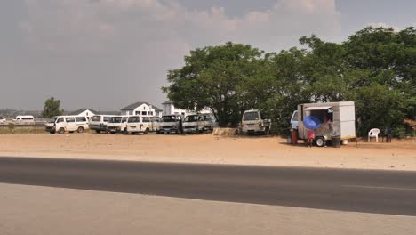 Informal-Taxi-stop-next-to-road-in-South-Africa,-with-food-vendor-in-trailer