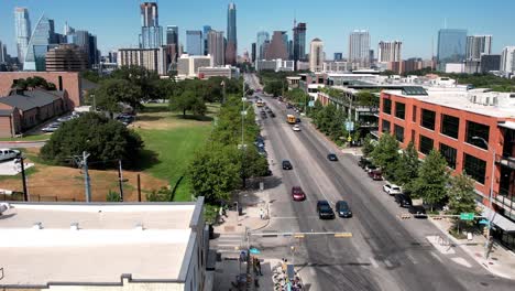 Aerial-drone-tilt-down-shot-over-two-way-roads-beside-Austin-Motel-in-Texas,-USA-on-a-busy-day