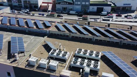 Solar-Panels-Installation-and-AC-Units-on-Rooftop-of-Shopping-Mall-in-Puente-Genil,-Spain,-Drone-Aerial-View