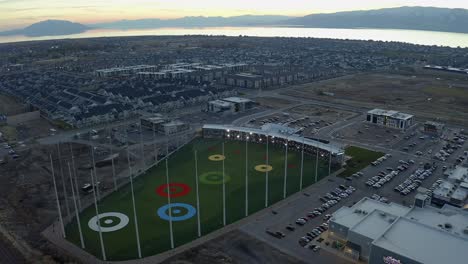 Orbiting-shot-of-the-new-Topgolf-driving-range-during-sunset-located-in-Vinyard,-Utah