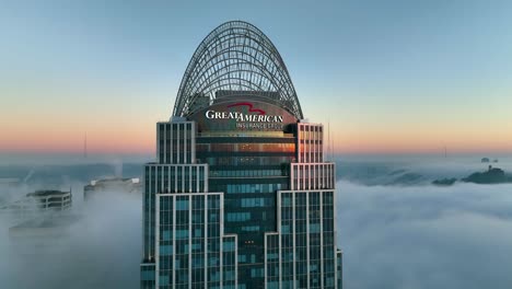 Aerial-view-around-the-fog-covered-Great-American-tower,-sunrise-in-Cincinnati,-USA---orbit,-drone-shot