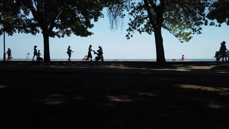 Sommerspaziergänger-Auf-Der-Strandpromenade-In-Toronto,-Umrahmt-Von-Einem-Ruhigen-Horizont-In-Der-Ferne