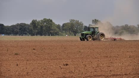 Hitzeschleier-Und-Staub-Steigen-Vom-Getreidefeld-Auf,-Während-Der-Traktor-Die-Zinkenegge-Schleppt