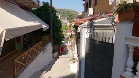 Gente-Caminando-Cuesta-Arriba-De-Un-Callejón-Encantador-En-Parga,-Grecia