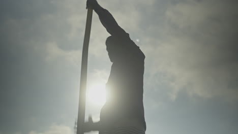 Silhouette-Boatman-rowing-with-oars-in-the-river-with-maximum-effort-in-slow-motion-60-fps