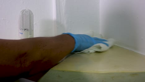 woman's-hands-in-blue-gloves-cleaning-shelf-of-room,-close-up,-Disinfection-concept