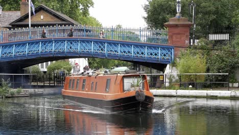 Barco-Estrecho,-Que-También-Es-Una-Casa-Flotante,-Navegando-Bajo-El-Puente-Azul-En-Little-Venice,-Londres,-Inglaterra