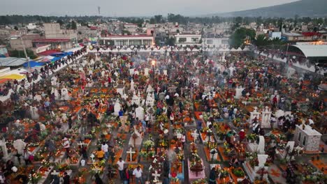 Aerial-view-over-people-decorating-tombstones-at-a-cementary,-during-the-day-of-the-dead,-in-Mexico-city