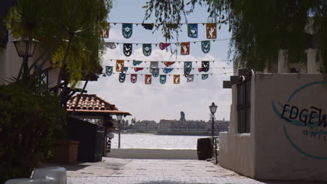 Colorful-Buntings-Hanging-Above-Pathway-At-Waterfront-Restaurant-By-The-San-Diego-Bay-In-San-Diego,-California,-USA