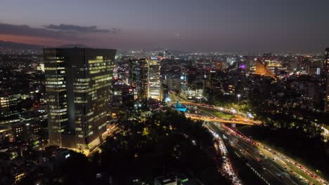 Vista-Aérea-Acercándose-A-La-Fuente-De-Petroleos,-Noche-En-La-Avenida-Reforma,-En-La-Ciudad-De-México