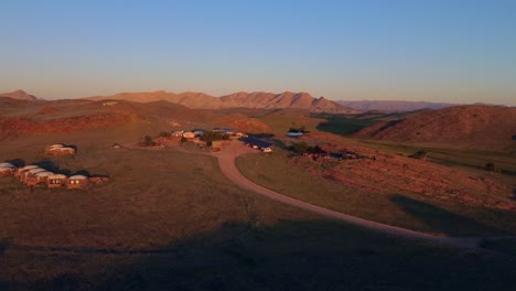 Toma-De-Drones-De-Una-Aldea-Africana-Durante-La-Puesta-De-Sol---Drones-Están-Dando-Vueltas-Sobre-La-Estepa-En-Namib-naukluft