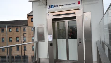 People-coming-up-the-lift-from-Victoria-Dock-Road-to-the-Excel,-London,-United-Kingdom