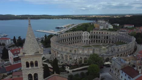 Drohnenaufnahme-Des-Amphitheaters-In-Pula,-Kroatien---Drohne-Fährt-An-Einer-Nahe-Gelegenen-Kirche-Vorbei