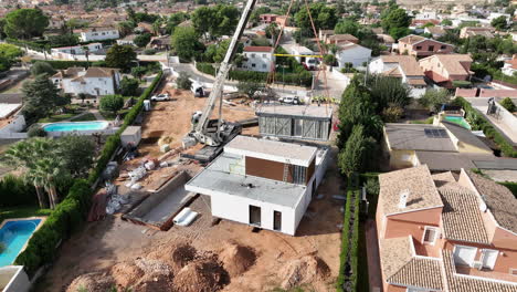 La-Grúa-Levanta-La-Estructura-Modular-Moderna-De-La-Casa-En-El-Sitio-De-Construcción,-Vista-Aérea