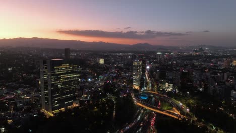 Aerial-view-of-the-Virreyes-building-and-the-Petroleos-Fountain,-dusk-in-Mexico-city---descending,-drone-shot