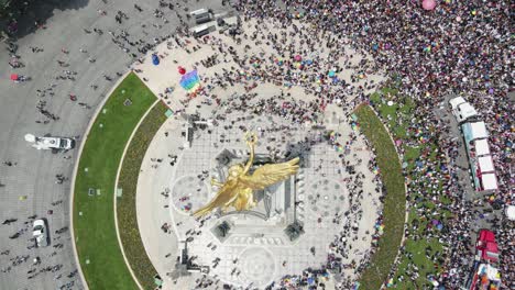 Cambio-De-Inclinación-Aérea-Sobre-La-Estatua-Del-ángel-Dorado-A-La-Multitud-Del-Día-Del-Orgullo-En-La-Calle