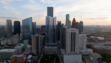 Aerial-view-approaching-the-sunlit-Texas-tower,-sunny-evening-in-Houston,-USA