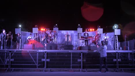 Famous-Group-performing-on-stage-in-Nimes,-France-at-night---dolly-forward-shot