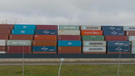 aerial-view-of-many-empty-metal,-rusted,-and-colored-sea-containers-lined-up-in-a-port-terminal