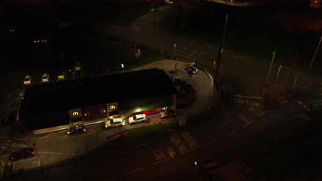 Night-flying-over-McDonalds-drive-through-aerial-view-orbiting-to-illuminated-highway