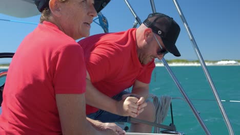 Man-spinning-the-handle-to-get-the-rope-back-on-a-sail-boat