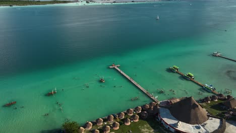 Vista-Aérea-Lejos-De-Los-Muelles-En-La-Ciudad-De-Bacalar,-Revelando-El-Canal-De-Los-Piratas-En-México---Levantándose,-Retrocediendo,-Tiro-De-Drones